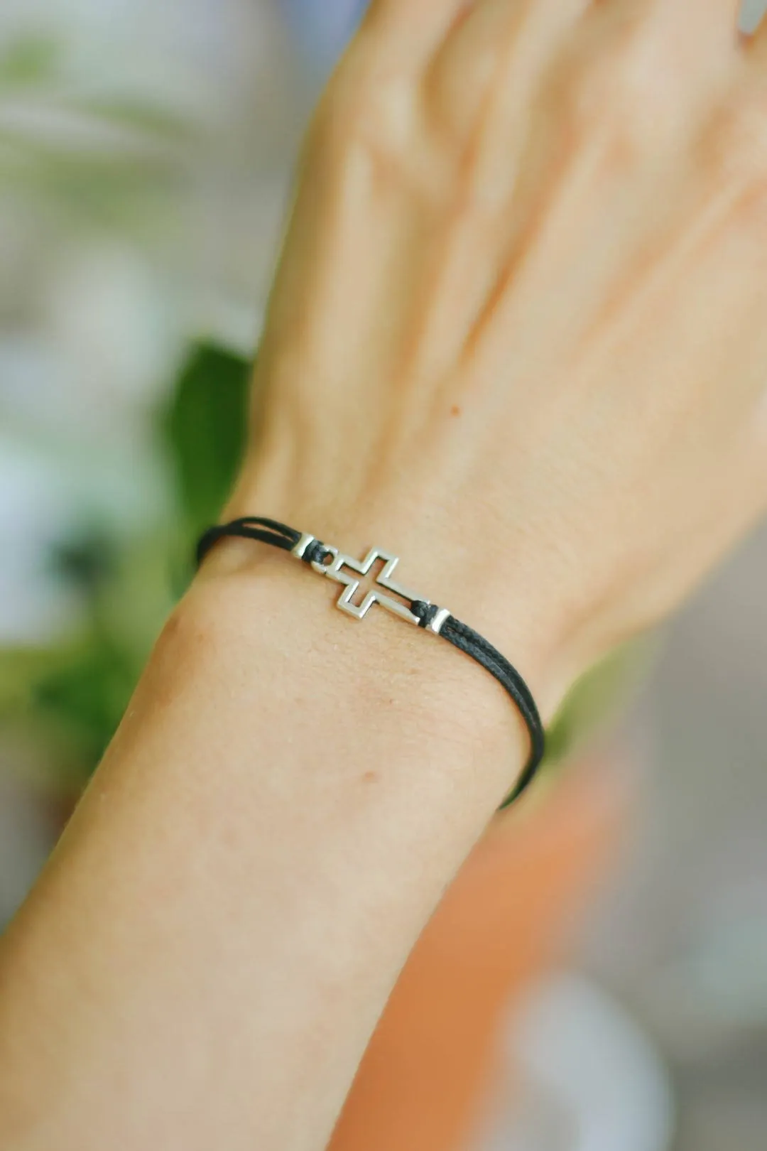 Women bracelet with silver outline cross charm, black cord