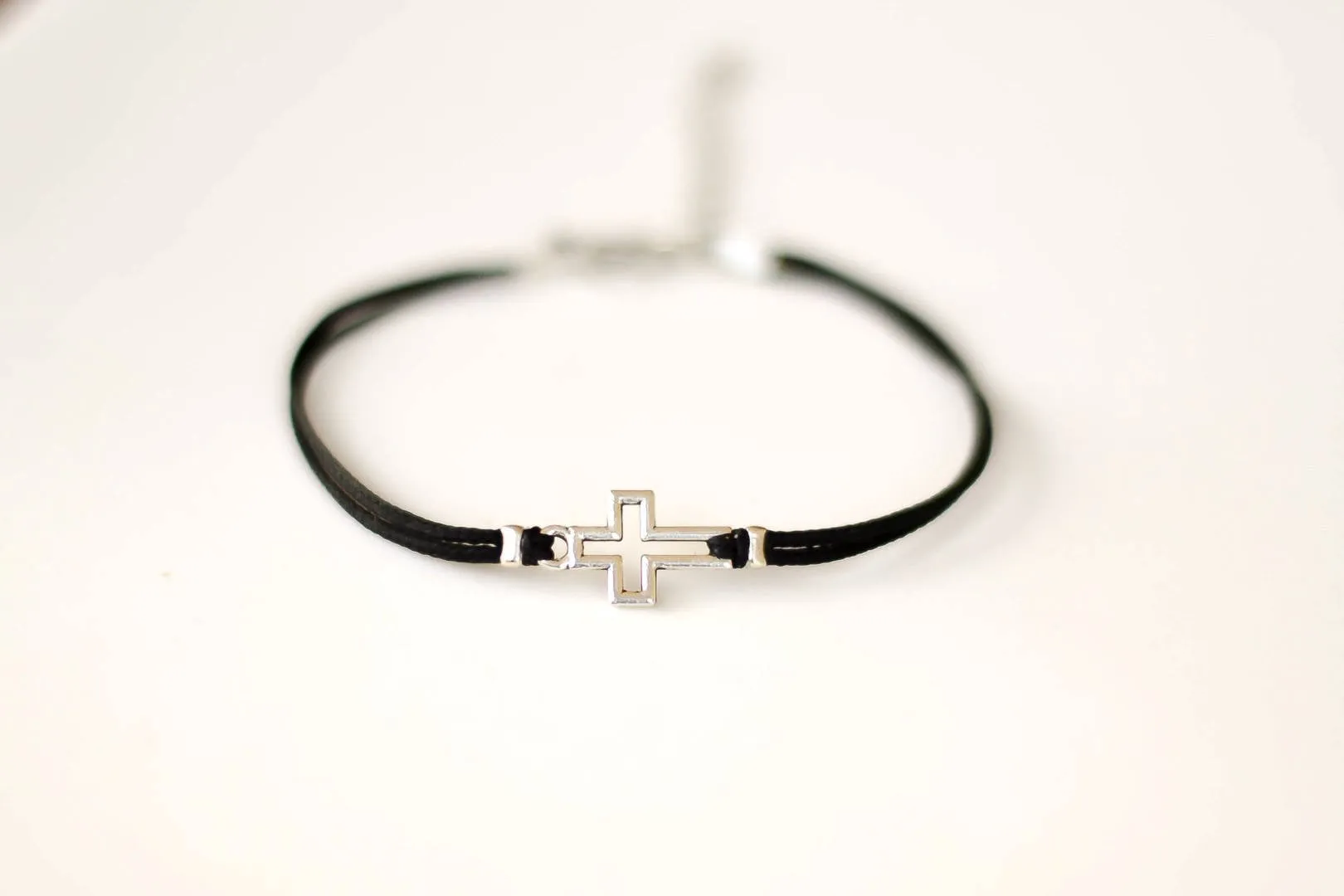 Women bracelet with silver outline cross charm, black cord