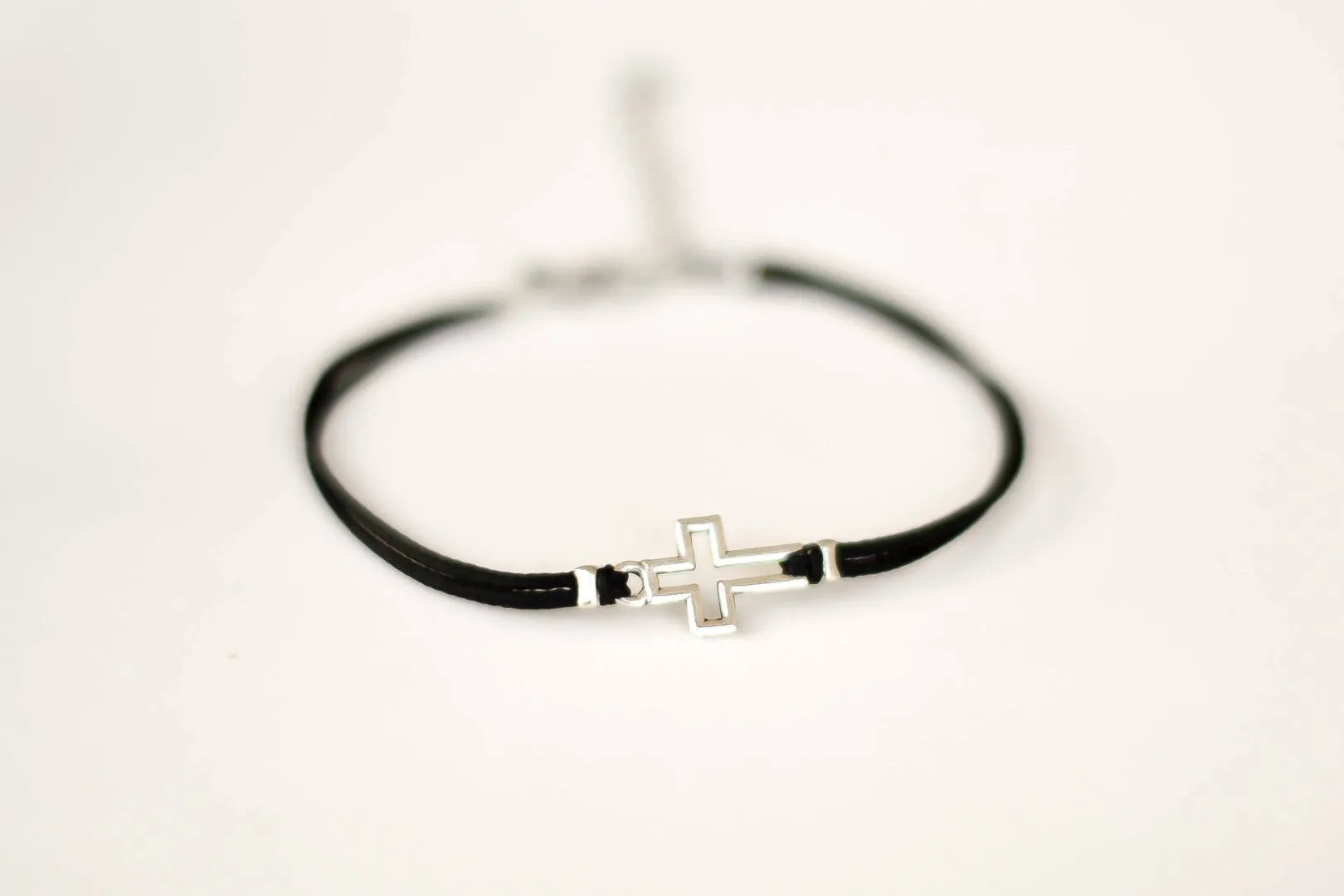 Women bracelet with silver outline cross charm, black cord