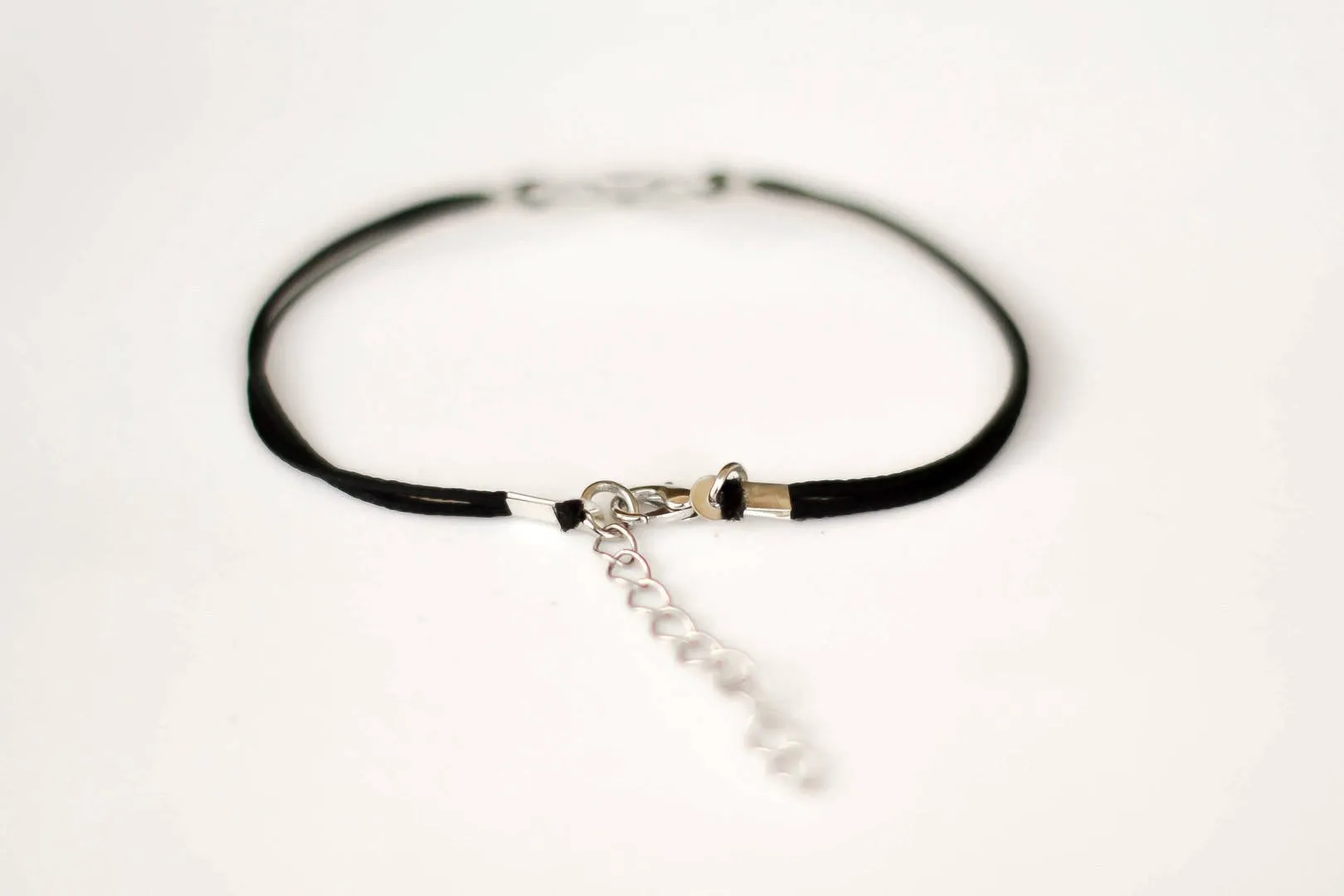 Women bracelet with silver outline cross charm, black cord